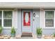 Close up of the red front door with glass detailing and potted plants at 290 Birch Ave, Orange City, FL 32763