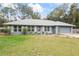 Charming single-story home featuring a red front door and a well-manicured front yard at 290 Birch Ave, Orange City, FL 32763