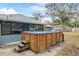 Relaxing hot tub in a wood surround with steps in the backyard at 290 Birch Ave, Orange City, FL 32763