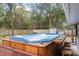 A backyard with a hot tub featuring a wooden panel surround with an attached table and bar stools at 290 Birch Ave, Orange City, FL 32763