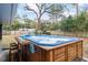 Backyard with a blue hot tub surrounded by wood paneling, with seating and a view of the yard at 290 Birch Ave, Orange City, FL 32763