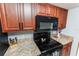 Cherry cabinets and granite countertops are features of this functional kitchen with black appliances at 290 Birch Ave, Orange City, FL 32763