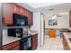 Cherry cabinets, granite countertops, and black appliances are features of this efficient kitchen at 290 Birch Ave, Orange City, FL 32763