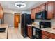 Galley kitchen featuring wood cabinets, solid surface counters, and stainless steel appliances at 290 Birch Ave, Orange City, FL 32763