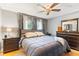 Comfortable main bedroom with a ceiling fan, wooden furniture, and a bright window at 290 Birch Ave, Orange City, FL 32763