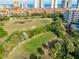 Scenic view of golfers on a golf course surrounded by lush greenery and condominium buildings at 3 Oceans West Blvd # 7C6, Daytona Beach, FL 32118