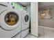 Laundry room featuring a modern washer and dryer with overhead shelving at 3 Oceans West Blvd # 7C6, Daytona Beach, FL 32118