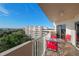 Balcony view showcasing community buildings and mature trees, complete with seating at 3 Oceans West Blvd # 7C6, Daytona Beach Shores, FL 32118