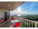 Balcony with red table and chairs, offering a beautiful view of the waterfront and surrounding landscape at 3 Oceans West Blvd # 7C6, Daytona Beach Shores, FL 32118