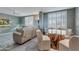 Bright living room with modern tile flooring, white shutters, and stylish glass-topped dining table at 3 Oceans West Blvd # 7C6, Daytona Beach Shores, FL 32118