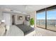 Neutral bedroom with carpet, ceiling fan, view from the large windows, and an ensuite bathroom at 3000 N Atlantic Ave # 11, Daytona Beach, FL 32118