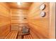 Home sauna with wood benches, wall mounted thermometers, and built in heater with stones at 3000 N Atlantic Ave # 11, Daytona Beach, FL 32118