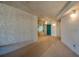 Exterior hallway featuring tile flooring, stucco walls, lighting sconces, and a teal unit door at 4555 S Atlantic Ave # 4708, Port Orange, FL 32127