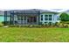 Exterior of the house featuring a screened-in porch, backyard, and manicured lawn at 1068 Sea Shell Ct, Daytona Beach, FL 32124