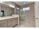 Bathroom featuring a shower with glass and tile, double sinks and a large mirror at 1068 Sea Shell Ct, Daytona Beach, FL 32124