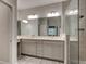 Bathroom featuring double sinks, a large mirror, and tiled shower with glass door at 1068 Sea Shell Ct, Daytona Beach, FL 32124