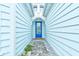 Inviting blue front door with wreath and welcome mat, framed by light blue siding at 1068 Sea Shell Ct, Daytona Beach, FL 32124