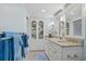 Bright bathroom featuring a double vanity, granite countertops and a built-in display cabinet at 1155 Ocean Shore Blvd # 507, Ormond Beach, FL 32176