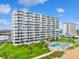 Beachfront condominiums on manicured lawn with a pool, lounge chairs, and palm trees at 1155 Ocean Shore Blvd # 507, Ormond Beach, FL 32176