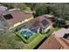 Aerial view of the home showcasing a screened pool, solar panels, and manicured landscaping at 5 Captiva At Lionspaw, Daytona Beach, FL 32124