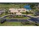 Aerial view of a luxury home, golf course, and entrance adorned with tropical palm trees at 5 Captiva At Lionspaw, Daytona Beach, FL 32124