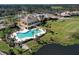 Aerial view of a clubhouse with a pool, patio and lush landscaping on a picturesque lot near a lake at 5 Captiva At Lionspaw, Daytona Beach, FL 32124