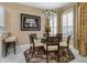 Dining room with round glass table, elegant chairs, decorative chandelier, and plantation shutters at 5 Captiva At Lionspaw, Daytona Beach, FL 32124