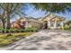 Charming one-story home featuring brick-paved driveway and lush, mature landscaping at 5 Captiva At Lionspaw, Daytona Beach, FL 32124