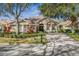 Charming home with a well-maintained front yard, mature trees, brick driveway, and decorative shutters at 5 Captiva At Lionspaw, Daytona Beach, FL 32124