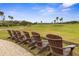 Scenic view of the lush golf course, featuring Adirondack chairs under a sunny sky and swaying palm trees at 5 Captiva At Lionspaw, Daytona Beach, FL 32124