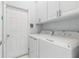 Efficient laundry room featuring front loading washer and dryer, with bright white cabinets and plenty of space at 5 Captiva At Lionspaw, Daytona Beach, FL 32124