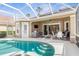 Backyard featuring a sparkling pool and spa, covered seating area, and lush landscaping at 5 Captiva At Lionspaw, Daytona Beach, FL 32124