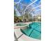 A screened-in pool with a built-in hot tub, surrounded by a well-maintained yard with mature landscaping at 5 Captiva At Lionspaw, Daytona Beach, FL 32124