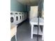 Functional laundry room featuring multiple washing machines, folding table, and sink at 840 Center Ave # 920, Holly Hill, FL 32117