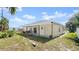 Spacious backyard featuring a covered patio, a lush lawn, and tropical plants at 11 Briggs Dr, Ormond Beach, FL 32176