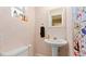 Cozy bathroom with patterned wallpaper, pedestal sink, and a mirror at 11 Briggs Dr, Ormond Beach, FL 32176