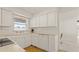 Bright kitchen featuring white cabinets, ample countertop space, and a window providing natural light at 11 Briggs Dr, Ormond Beach, FL 32176