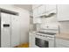Well-lit kitchen with white appliances, including a refrigerator and oven, complemented by white cabinets at 11 Briggs Dr, Ormond Beach, FL 32176
