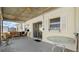 Inviting covered patio featuring wicker seating, a glass table, and sliding glass doors at 11 Briggs Dr, Ormond Beach, FL 32176
