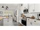 Bright kitchen featuring white cabinets, stainless steel appliances, and granite countertops at 111 Heron Dunes Dr, Ormond Beach, FL 32176