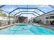 Screened-in pool area with in-ground pool, paved patio, and lounge chairs at 111 Heron Dunes Dr, Ormond Beach, FL 32176