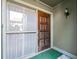 Close-up of the stained wood front door with secured storm door at 128 Pine Cone Trl, Ormond Beach, FL 32174