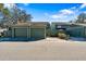 View of the detached single car garages and green wooden fence at the front of the townhomes at 128 Pine Cone Trl, Ormond Beach, FL 32174