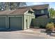 View of the detached single car garage and green wooden fence gate at the front of the townhome at 128 Pine Cone Trl, Ormond Beach, FL 32174