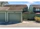 View of the detached single car garage and green wooden fence gate at the front of the townhome at 128 Pine Cone Trl, Ormond Beach, FL 32174