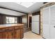 Vintage kitchen with wood cabinets and patterned wallpaper, adjacent to refrigerator, in need of updating at 128 Pine Cone Trl, Ormond Beach, FL 32174