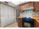 Vintage kitchen with wood cabinets, cook top, and patterned wallpaper in need of updating at 128 Pine Cone Trl, Ormond Beach, FL 32174