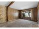 Vintage living room with paneled walls, plush carpeting, large windows and exposed beam in need of updating at 128 Pine Cone Trl, Ormond Beach, FL 32174