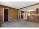 Vintage living room with paneled walls, plush carpeting, and wood beam opens to kitchen in need of updating at 128 Pine Cone Trl, Ormond Beach, FL 32174