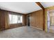Vintage living room with paneled walls, plush carpeting, and large windows in need of updating at 128 Pine Cone Trl, Ormond Beach, FL 32174
